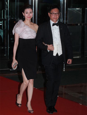 李嘉欣短裙配高跟鞋亮相婚宴 与老公手挽手现身